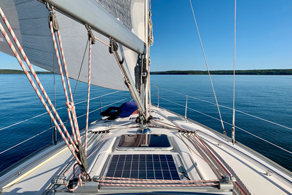 Dekorativ bild från segelbåt med mast och för på en stilla sjö.