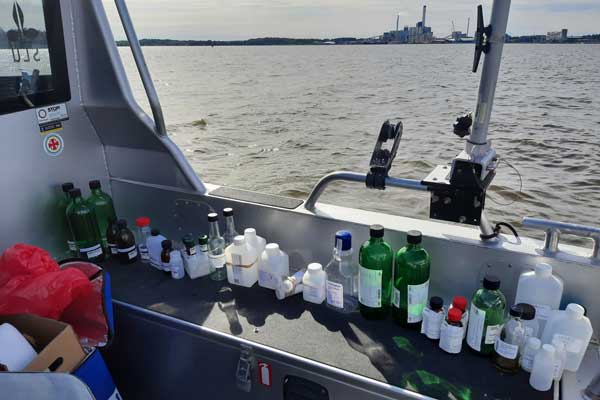 Många, cirka 35, provtagningsflaskor på rad ombord på en båt under en provtagning i Mälaren.